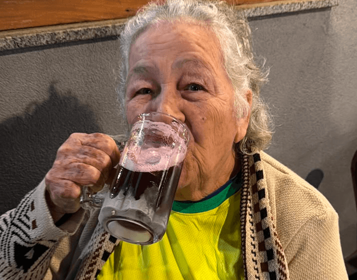 Com 83 anos, Maria foi para o bar ver jogo do Brasil tomando uma gelada no frio