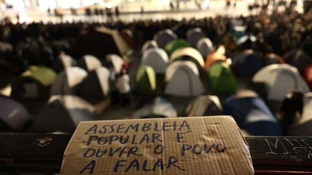 Voluntários limpam chão da praça no Porto para evitar terem de levantar tendas